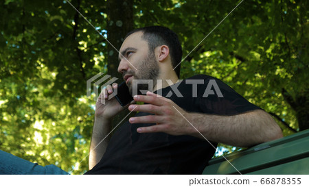 Man on the phone outdoors looking concerned. Man on the phone outdoors looking concerned. 66878355