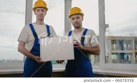 Two sad builders with boardsheet or poster looking for a job. Two sad builders with boardsheet or poster looking for a job. 66878358