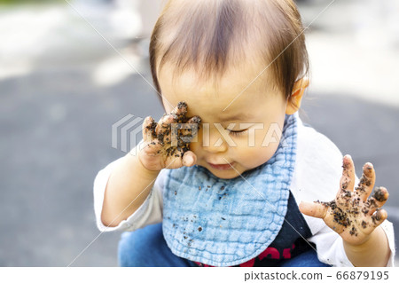 Play in the sandbox Baby rubbing his hands with the sand Rub his eyes with his dirty hands Play in the sandbox Baby rubbing his hands with the sand Rub his eyes with his dirty hands 66879195