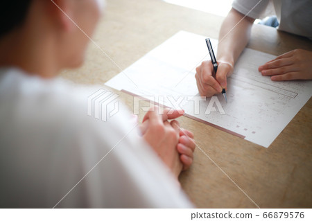 A couple completing a marriage registration A couple completing a marriage registration 66879576