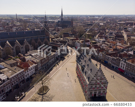 Aerial drone Photo of the Dutch City Gouda where gouda cheese is made. City center with lots of historical buildings and churches including the city hall and the cheese market 66880433