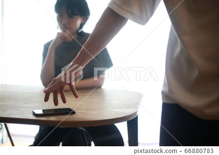 A man who takes out a smartphone 66880783