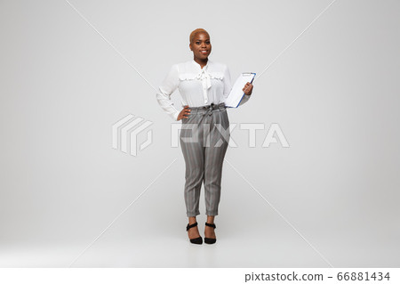 Young african-american woman in office attire on gray background. Bodypositive female character. plus size businesswoman Young african-american woman in office attire on gray background. Bodypositive female character. plus size businesswoman 66881434