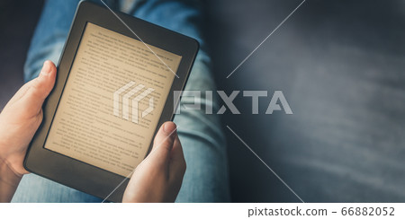 Girl is reading ebook on digital tablet device 66882052