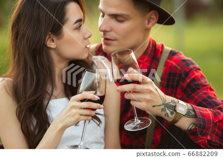 Caucasian young and happy couple enjoying a picnic in the park on summer day Caucasian young and happy couple enjoying a picnic in the park on summer day 66882209