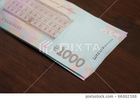 Pack of new 1000 hryvnias bill backside. Ukrainian thousands paper money at wooden table. Cash money concept. Macro or close up shot 66882388