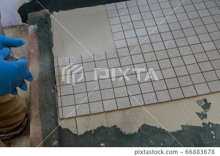 Tiler and plaster repair work laying tile, trowel 66883678