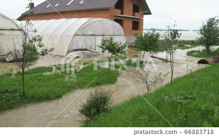Flooded field with farm after heavy rains storm 66883718