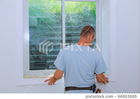Worker installing trim around a window 66883880