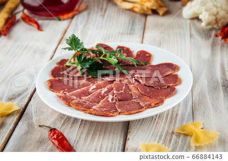 Sliced basturma slices herbs wooden background Sliced basturma slices herbs wooden background 66884143