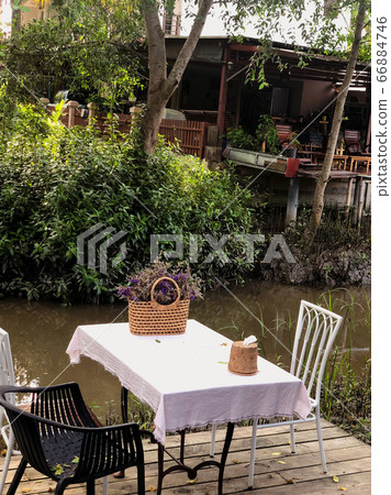 Cafe tables and chairs outside with local tropical background. 66884746