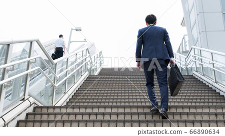 Rear view of businessman climbing stairs Rear view of businessman climbing stairs 66890634