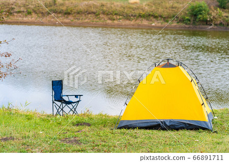 Rest with a tent in the woods by the river. The 66891711