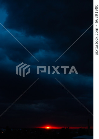 Black thunderclouds at sunset. Bright orange 66891980