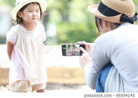 媽媽給孩子拍照在智能手機的沙箱中玩 66894148