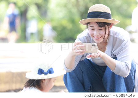 媽媽給孩子拍照在智能手機的沙箱中玩 66894149
