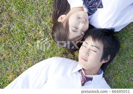 High school couple lying on the lawn 66895051