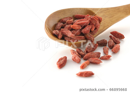 Wolfberry (white background) spilling from a wooden lotus flower 66895668