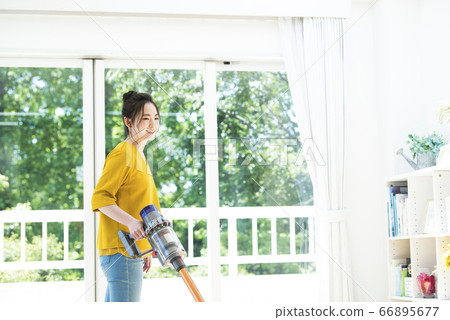 Young woman vacuum cleaner 66895677