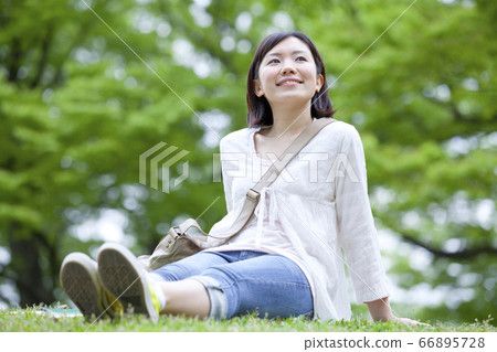 一個女孩坐在草坪上 一個女孩坐在草坪上 66895728