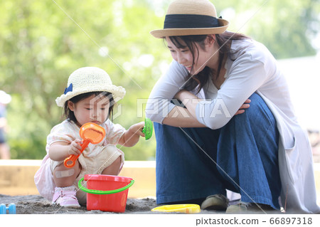 父母和孩子們在沙盒中玩耍 父母和孩子們在沙盒中玩耍 66897318