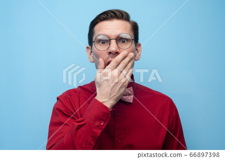 Portrait of shocked surprised young man in glasses Portrait of shocked surprised young man in glasses 66897398