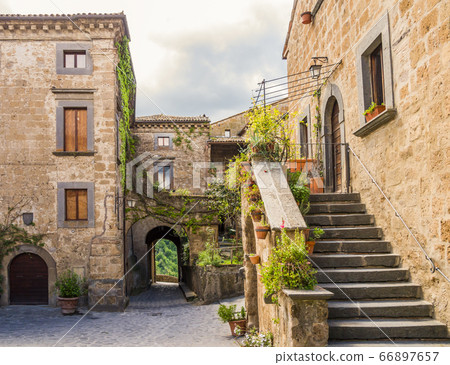 Idyllic inner alley of Civita di Bagnoregio, ghost mediaeval town built above a plateau of friable volcanic tuff, Lazio, central Italy 66897657
