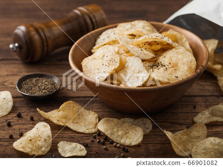 Black pepper taste potato crisps chips in wooden 66901082