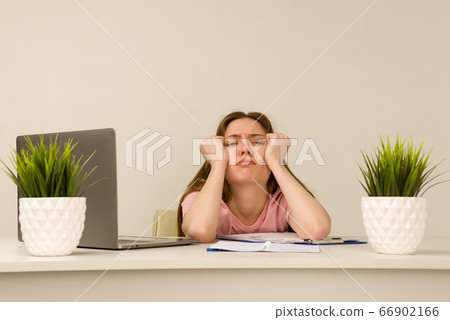 Tired overworked young intern woman working with a Tired overworked young intern woman working with a 66902166