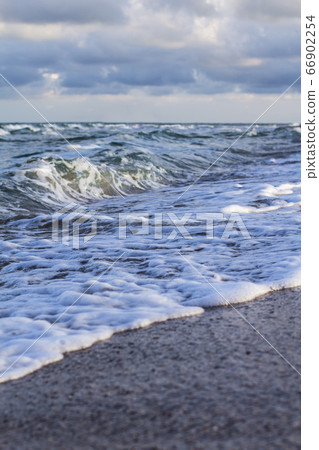 Sea waves, sandy beach and clouds 66902254