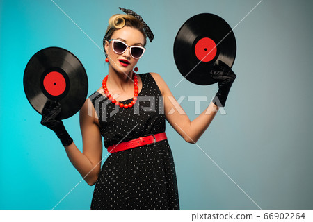 A photo of glamorous pin-up girl holding vinyl LP A photo of glamorous pin-up girl holding vinyl LP 66902264