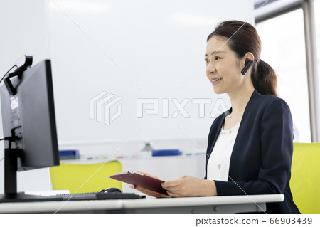 Online interview image of a business woman heading to a desktop computer with a webcam 66903439