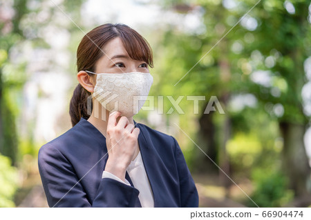 A young woman on the way to work wearing a fashionable lace mask 66904474
