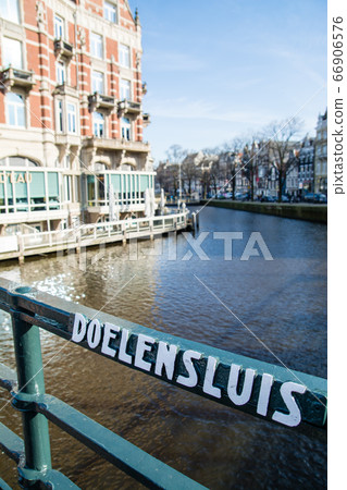 Bridge with building names written along the Amsterdam river in the Netherlands Bridge with building names written along the Amsterdam river in the Netherlands 66906576