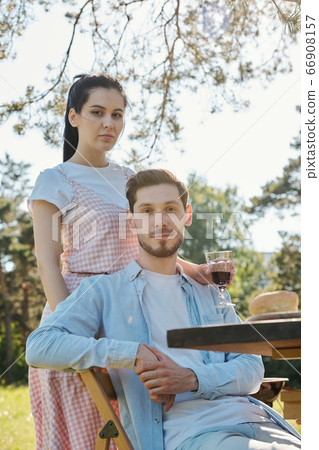 Amorous young couple of Caucasian ethnicity in casualwear relaxing outdoors 66908157