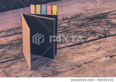 Abstract notebook with color note tab. Notebook with colors note tab on wooden table background, Vintage picture tone. Abstract notebook with color note tab. Notebook with colors note tab on wooden table background, Vintage picture tone. 66916316