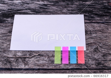 Abstract white paper with color note tab. blank paper with colorful note tab on wooden table background, Vintage picture tone. Abstract white paper with color note tab. blank paper with colorful note tab on wooden table background, Vintage picture tone. 66916317
