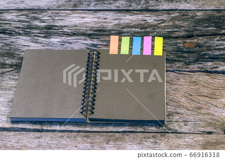 Black notebook with colors note tab on wooden table for add message or copy space for add text. Case study concept Black notebook with colors note tab on wooden table for add message or copy space for add text. Case study concept 66916318