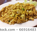 Stir fried crab meat, curry powder, egg and spring onions in a white dish 66916483