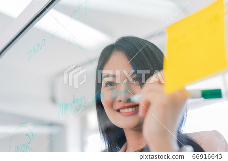 business woman working and writing on the glass board in office. Lifestyle female work concept business woman working and writing on the glass board in office. Lifestyle female work concept 66916643
