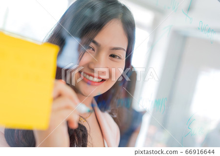 business woman working and writing on the glass board in office. Lifestyle female work concept business woman working and writing on the glass board in office. Lifestyle female work concept 66916644