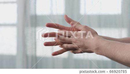 man apply liquid sanitizer on his hands standing in front of the window closeup man apply liquid sanitizer on his hands standing in front of the window closeup 66920785