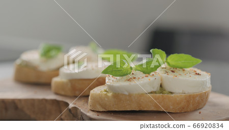 bruschetta with pesto and mozzarella on olive board 66920834