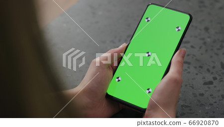 young woman holding smartphone over terrazzo countertop 66920870