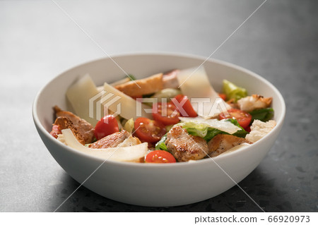 Fresh caesar salad with chicken and cherry tomatoes in white bowl Fresh caesar salad with chicken and cherry tomatoes in white bowl 66920973