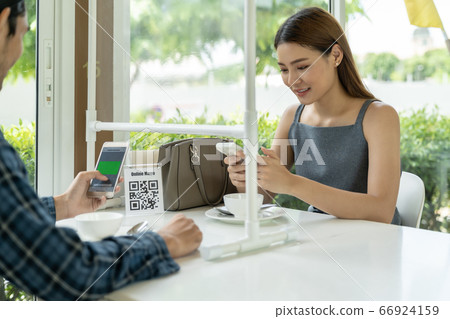 Asian customer scanning QR code for online menu un 66924159