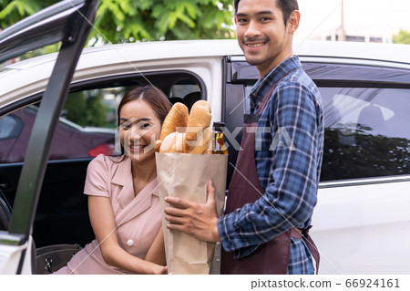 Asian woman take delivery grocery bag from Drive 66924161