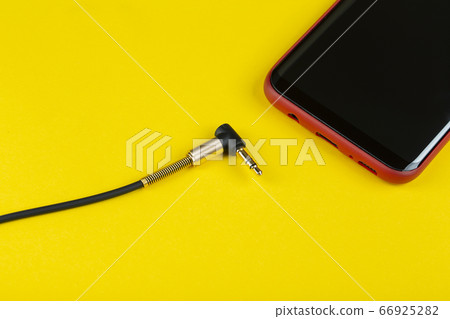 Close-up Jack plug and a cable with phone on a Close-up Jack plug and a cable with phone on a 66925282