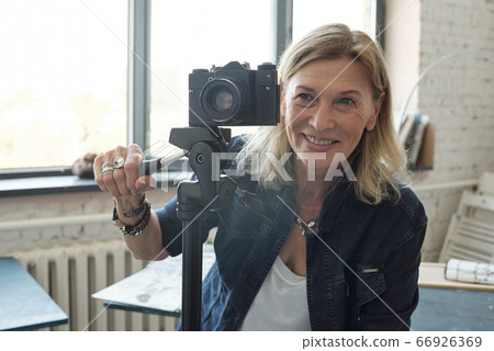 Mature lady photographer enjoying photo shoot Mature lady photographer enjoying photo shoot 66926369