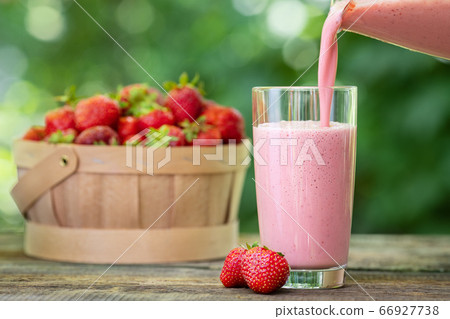 strawberry milkshake pouring in glass strawberry milkshake pouring in glass 66927738